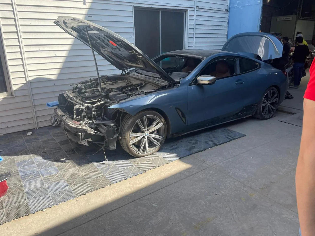 BMW Serie 8 azul ingresando al taller de reparación de airbags en Santiago