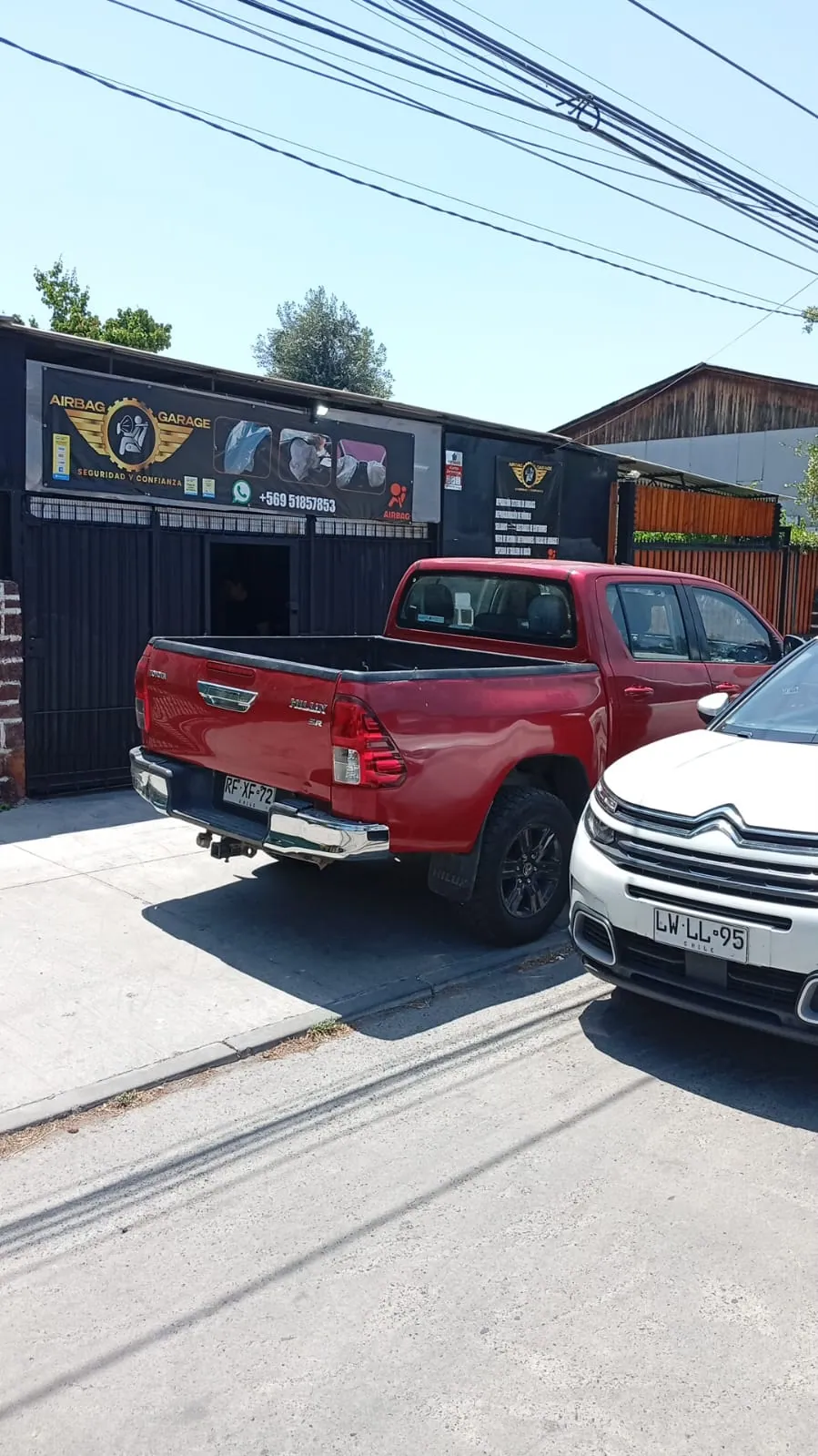 Toyota Hilux roja en el frontis del taller Airbags Restauración en La Cisterna
